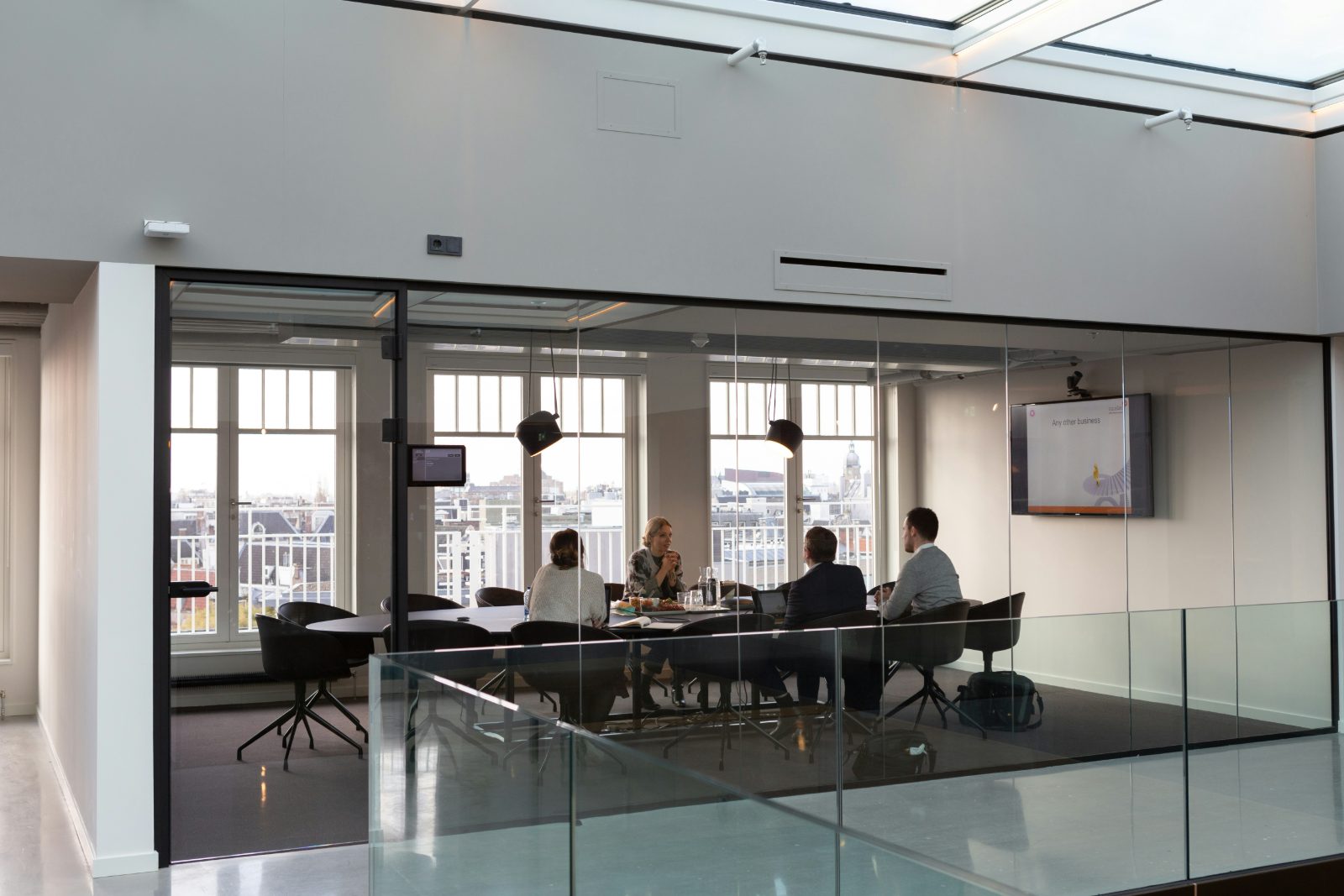 A team meeting in a bright glass-walled boardroom